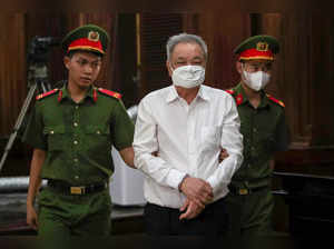 Vietnamese soft drink boss Tran Qui Thanh (C) is led into a court in Ho Chi Minh City on April 25, 2024.