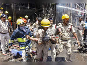 Patna: Firefighters rescue an injured after a fire broke out in a hotel near the...