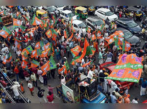 Thiruvananthapuram: BJP supporters wave the party flags during a roadshow ahead ...