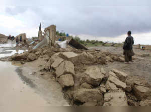 Residents gather beside a damaged house after heavy rains on the outskirts of Chaman in Balochistan province on April 19, 2024.