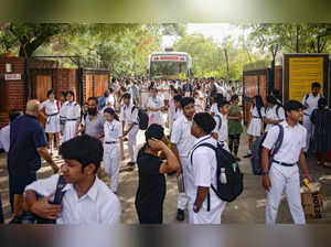 Noida: Students come out of the DPS School after a bomb threat was received by t...