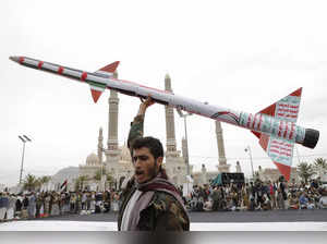 A Houthi supporter raises a mock rocket during a rally against the U.S. and Isra...