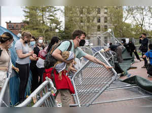 Pro-Palestinian supporters tear down the wall as they retake the encampment at the Massachusetts Institute of Technology (MIT) in Cambridge, Massachusetts, on May 6, 2024.