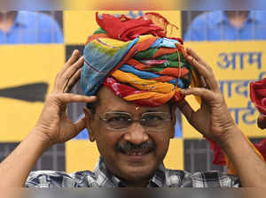 Aam Aadmi Party (AAP) leader and chief minister of Delhi Arvind Kejriwal puts on a turban during a press conference at the party headquarters in New Delhi on May 11, 2024, a day after being release on bail by India's top court.