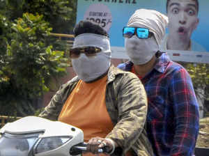 Amritsar: Commuters use scarves to shield themselves from the heat wave on a hot...
