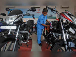 FILE PHOTO: A worker cleans a bike inside a Hero MotoCorp showroom in Mumbai
