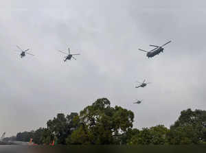 New Delhi: A chinook flies past with other choppers in a formation during the fu...