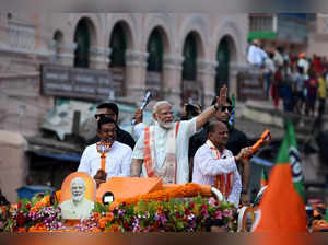 India's PM Modi waves to his supporters during a roadshow in Puri