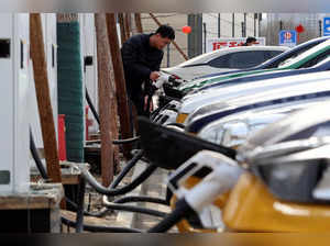 A man charges a car at an EV charging station