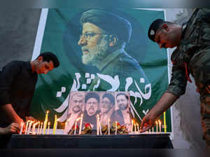 Iraqis place flowers and light candles for Iran's late president Ebrahim Raisi (pictured) outside the Iranian embassy in Baghdad during a condolences service on May 20, 2024 for the president and his entourage, who were killed in a helicopter crash in Iran the previous day.