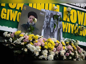 Portraits of Iran's late President Ebrahim Raisi are seen with flower bouquets outside the Iranian embassy in Jakarta on May 21, 2024, following his death in a helicopter crash in a remote area of northwestern Iran.