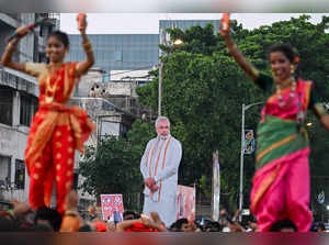 Dancers perform near a cut out of Indian Prime Minister Narendra Modi and leader of the ruling Bharatiya Janata Party (BJP) during a Modi roadshow in Mumbai on May 15, 2024, ahead of the fifth phase of voting of India's general election.