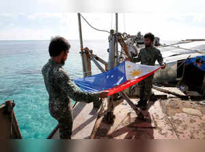 FILE PHOTO: Philippine Marines fold a Philippine national flag during a flag retreat at the BRP Sierra Madre, a marooned transport ship in the disputed Second Thomas Shoal