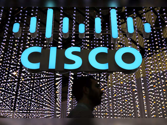 FILE PHOTO: A man passes under a Cisco logo at the Mobile World Congress in Barcelona