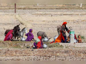 Women gather for washing and to fetch water at a handpump during a hot summer day on the outskirts of Larkana