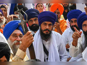 Chief of a social organisation, Amritpal Singh (C) along with devotees takes part in a Sikh initiation rite ceremony also known as ‘Amrit Sanskar’ at Akal Takht Sahib in the Golden Temple in Amritsar on October 30, 2022.