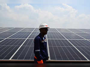 Franck Alain Yayo, operations engineer of the photovoltaic solar power plant, stands near the photovoltaic panels at the Boundiali solar power plant in Boundiali on May 22, 2024.