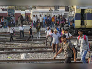 Lucknow: Passengers cross railway tracks at Charbagh railway station, in Lucknow...