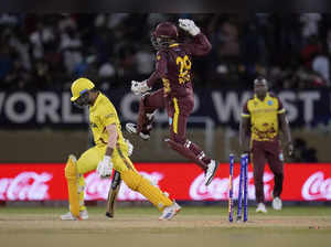 West Indies wicket keeper Nicholas Pooran jumps into the air in celebration as h...