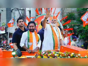 Hyderabad: Prime Minster Narendra Modi waves at the crowd during a road show, ah...