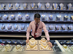 FILE PHOTO: A salesman displays gold necklaces and earrings inside a jewellery showroom on the occasion of Akshaya Tritiya, a major gold buying festival, in Mumbai