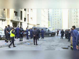 Rescuers arrive at the site of a building that caught fire in Kuwait. At least 4...