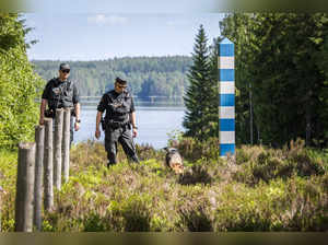 Finnish Border guards Loujas and Piitulainen with dog Nita patrol in Joensuu at the border with Russia on June 5, 2024 during a press event.