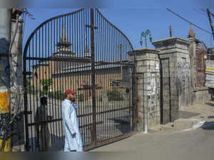 Srinagar: A man outside the locked gate of Jamia Masjid after authorites disallo...