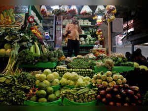 FILE PHOTO: Debashis Dhara, a vegetable vendor, speaks on his mobile phone at a retail market area in Kolkata