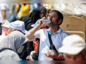 A departing Turkish Muslim pilgrim drinks cold water from a bottle as he waits in the shade in Saudi Arabia's holy city of Mecca on June 20, 2024.