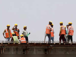FILE PHOTO: Workers drink water as they take a break at a construction site on a hot summer day