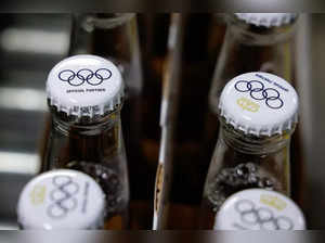 This photograph taken on April 23, 2024 shows crown caps covering beer bottles filled with Olympics logo on bottles of Corona Cero alcohol-free beer on a production line during a press visit at the Anheuser-Busch InBev (AB InBEV) brewery in Leuven