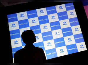 FILE PHOTO: A man walks past a screen displaying Tata Steel logo before the start of a news conference in Mumbai