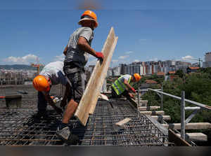 Construction workers work on a bulding during hot weather, in Pristina