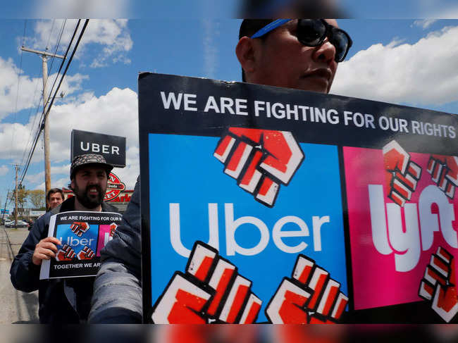 FILE PHOTO: Uber and Lyft drivers protest during a day-long strike outside Uber’s office in Saugus