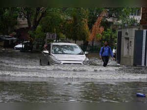 New Delhi: A vehicle wades through a waterlogged road amid rains, in New Delhi, ...