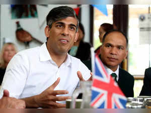 Britain's Prime Minister and Conservative Party Leader, Rishi Sunak (3R), speaks to veterans and former members of the Armed Forces, at a cafe on Armed Forces Day, during a general election campaign visit in his Richmond and Northallerton constituency in northeast England, on June 29, 2024.