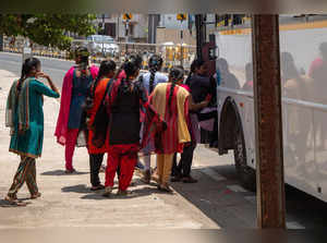 FILE PHOTO: Women board a Foxconn factory bus near the village of Molachur