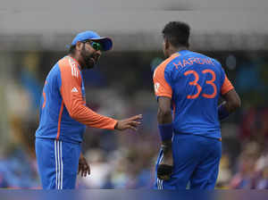 India's Hardik Pandya, right, listens to captain Rohit Sharma before bowling his...