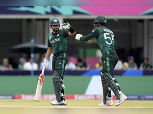 Pakistan's Abbas Afridi, right, moves to touch gloves with captain Babar Azam as...