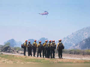 US Forest Service firefighters stand watch as the Post Fire burns through Castaic, California, June 16, 2024.
