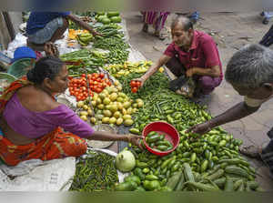 Kolkata: Vegetable vendors attend customers as vegetable prices soar, in Kolkata...