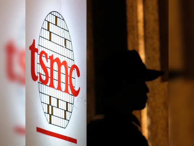 A security staff stands next to a logo of the Taiwan Semiconductor Manufacturing Co, (TSMC), during the investors conference in Taipei on July 16, 2014.