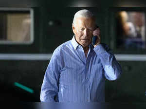 US President Joe Biden speaks on the phone while walking from Marine One to board Air Force One before departing McGuire Air Force Base in New Jersey on June 29, 2024.