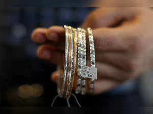 FILE PHOTO: A salesman displays platinum bangles for the camera at a jewellery showroom in Mumbai