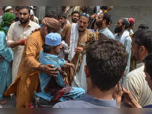 People transport an injured protester (C) following gunfire that broke out during a protest rally against the military operation in Pakistan, in Bannu, some 40 kilometres from Afghanistan, on July 19, 2024.