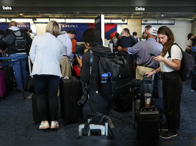 Travelers line up at Milwaukee General Mitchell International Airport due to a worldwide tech outage caused by an update to CrowdStrike's "Falcon Sensor" software