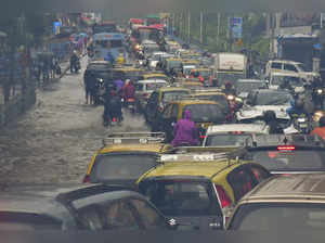 Mumbai: Vehicles move on a waterlogged road after heavy monsoon rain, at Dadar i...