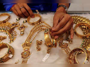 FILE PHOTO: A woman looks at a gold bangle inside a jewellery showroom at a market in Mumbai