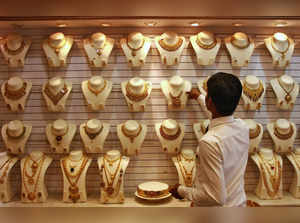 FILE PHOTO: FILE PHOTO: A salesman arranges a gold necklace inside a gold jewellery showroom in Kochi